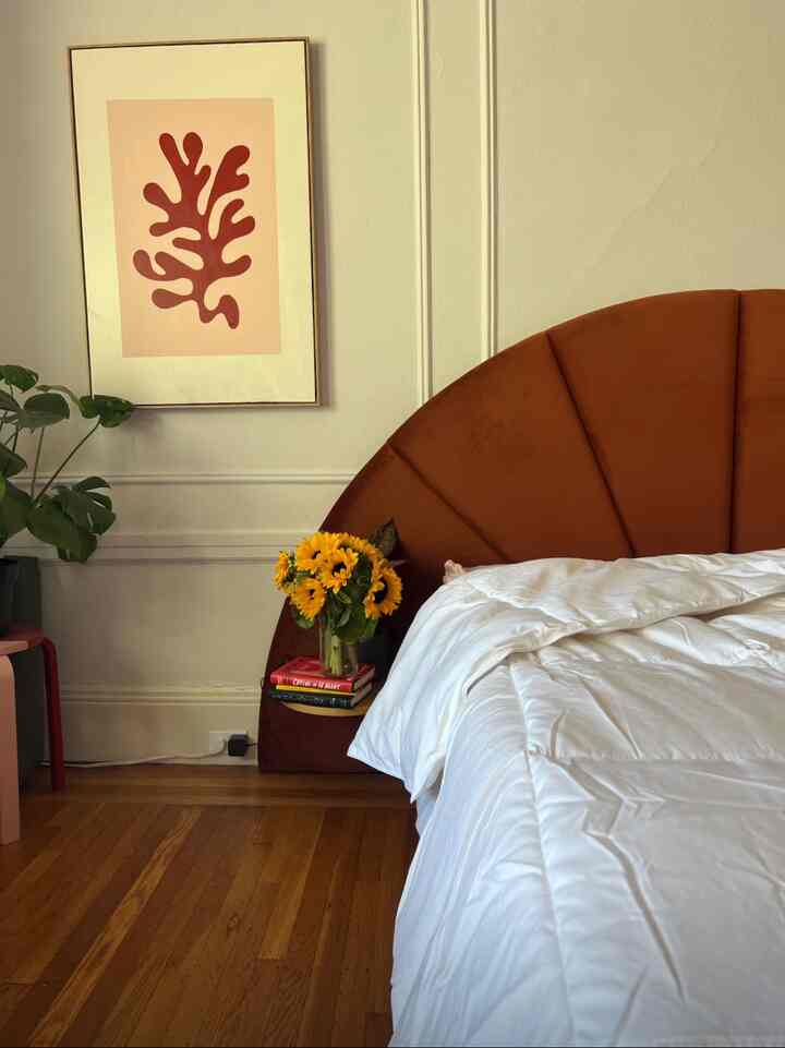 Warm brown-toned bedroom featuring an Almelo headboard bed and a side table with sunflower vase