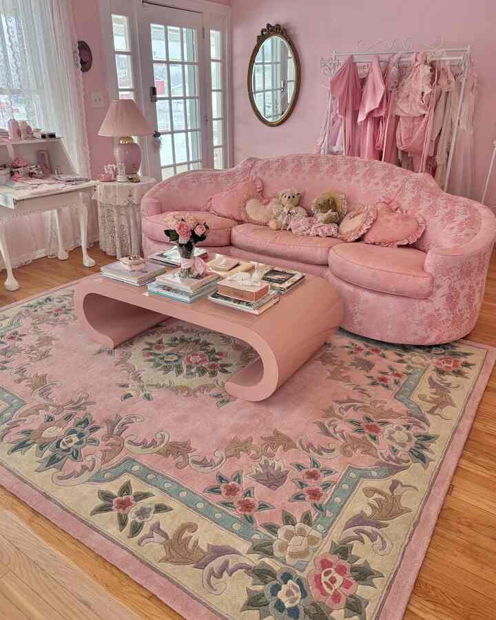 Pastel pink toned living room featuring floral sofa and rug with retro shabby chic charm
