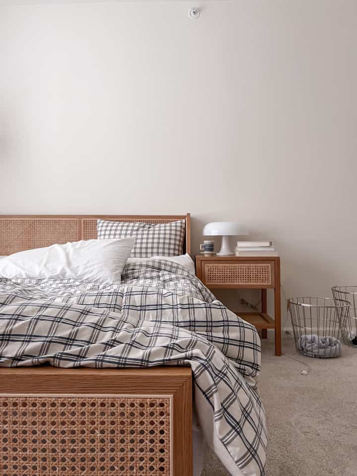 Beige-toned bedroom featuring natural rattan bed frame and nightstand, creating a cozy and simple atmosphere