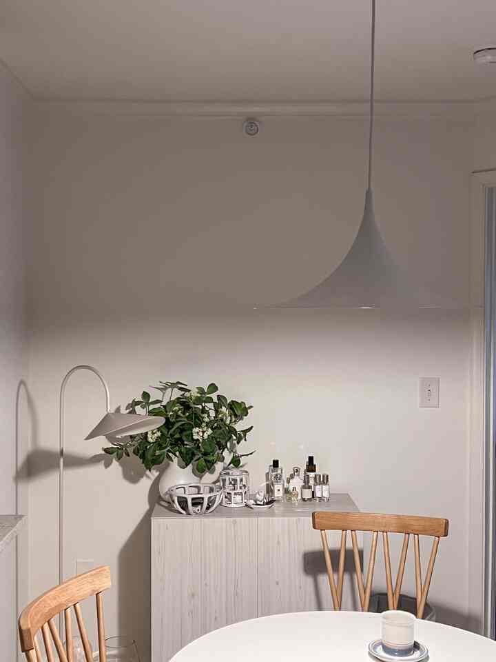 Natural toned dining room featuring wooden chairs and white pendant light with a modern atmosphere