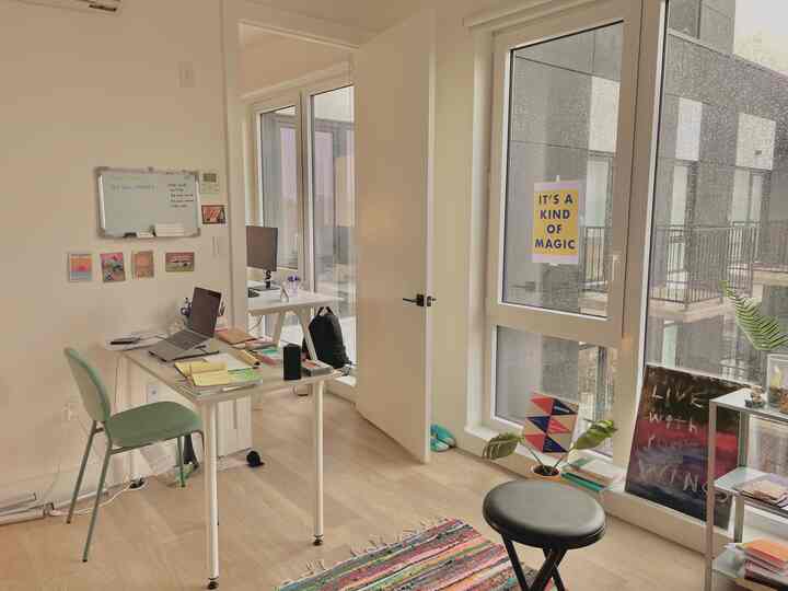 Nordic-style home office with white walls and natural wood flooring, featuring a desk and chairs in a clean workspace layout