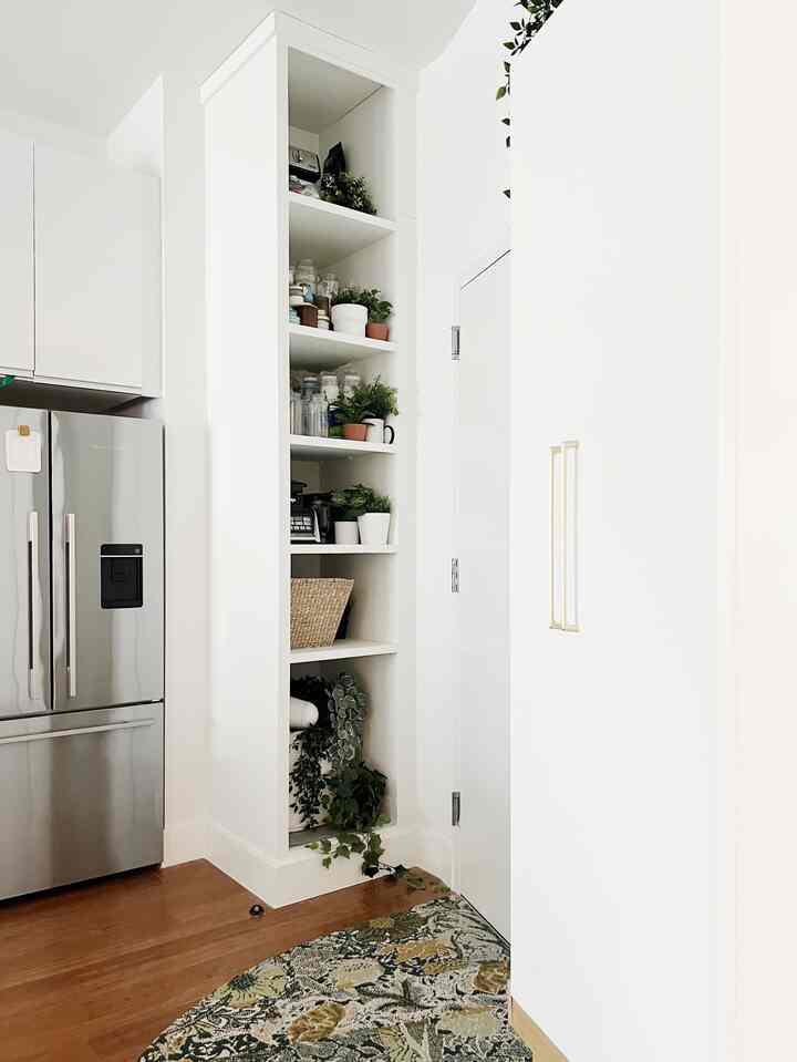 I use plants to turn unsightly storage into something more pleasing to look at. And would you know that the basket on the second to bottom shelf is for recycling?

#organization #storage #plants #fauxplants #diy #ikeapax #ikeahack #kitchen #entryway #pantry #openstorage #bohemian #white