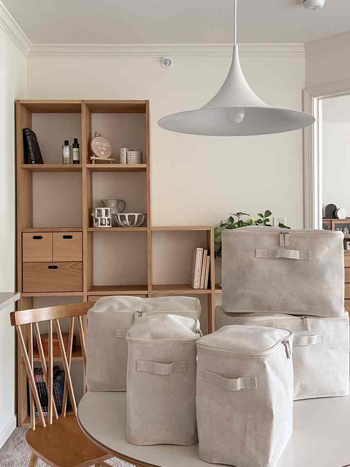 Beige and wood-toned Japandi style interior featuring storage solutions and natural elements with a pendant light overhead