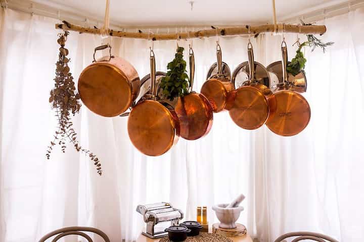 Hang your copper pots to showcase them! 
It’s also a great way to store them as they need to be in a well ventilated area. Hanging the lids together saves much more space too! #kitchen #organize #kitcheninterior #copper #copperpots 