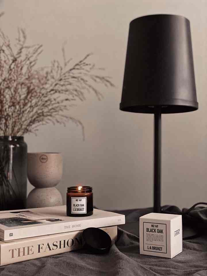 Beige and brown toned dining room table featuring a lit candle and table lamp with a cozy atmosphere