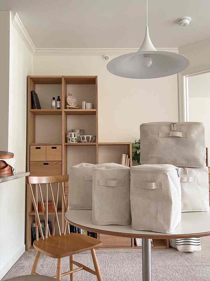 Natural toned living room featuring wood shelving and beige modular storage boxes creating a cozy atmosphere