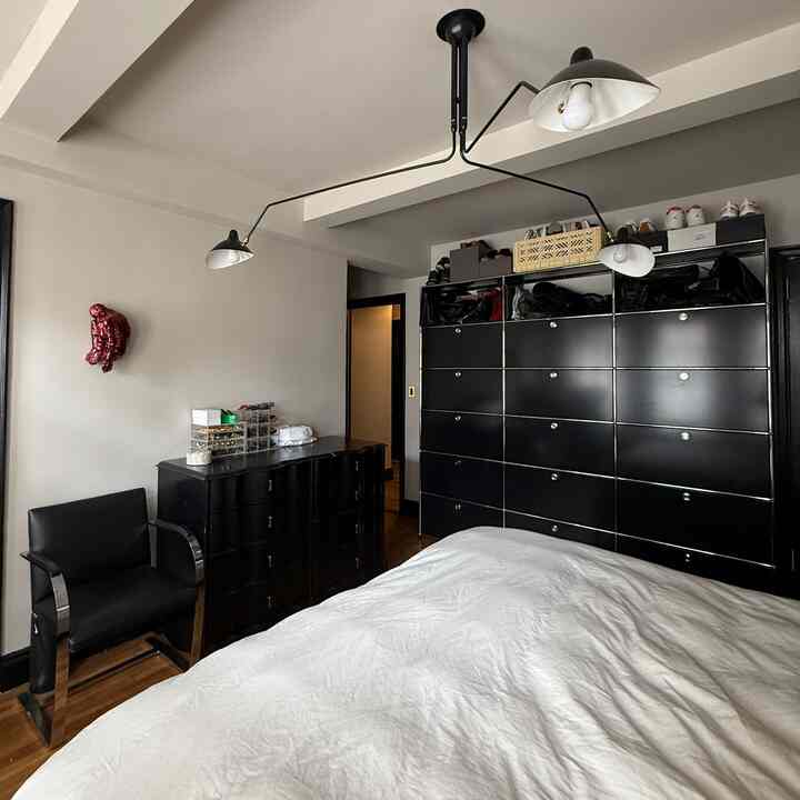 Modern bedroom featuring black furniture contrasted with white bedding and walls