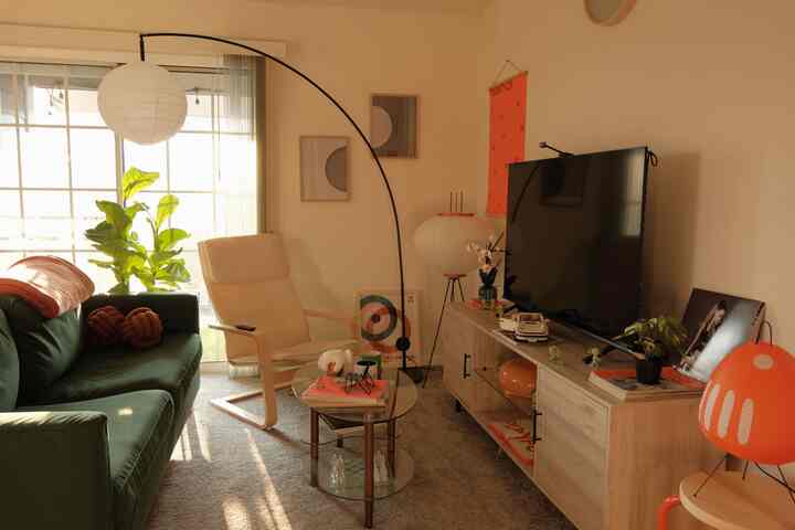 Beige and green toned living room featuring sofa and armchair with cozy atmosphere