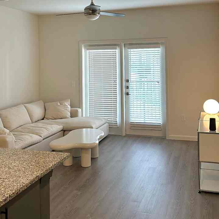 Bright white-toned walls and floor featuring beige sofa and unique white coffee table in a simple minimal living room