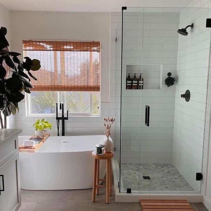 Natural wood tones and white modern bathroom featuring bathtub, shower enclosure, and wooden stool in cozy setting