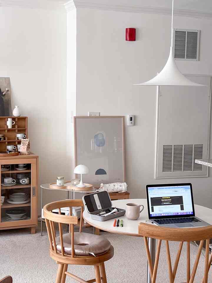 Beige-walled home office with wood tone furniture and minimalist home cafe setup