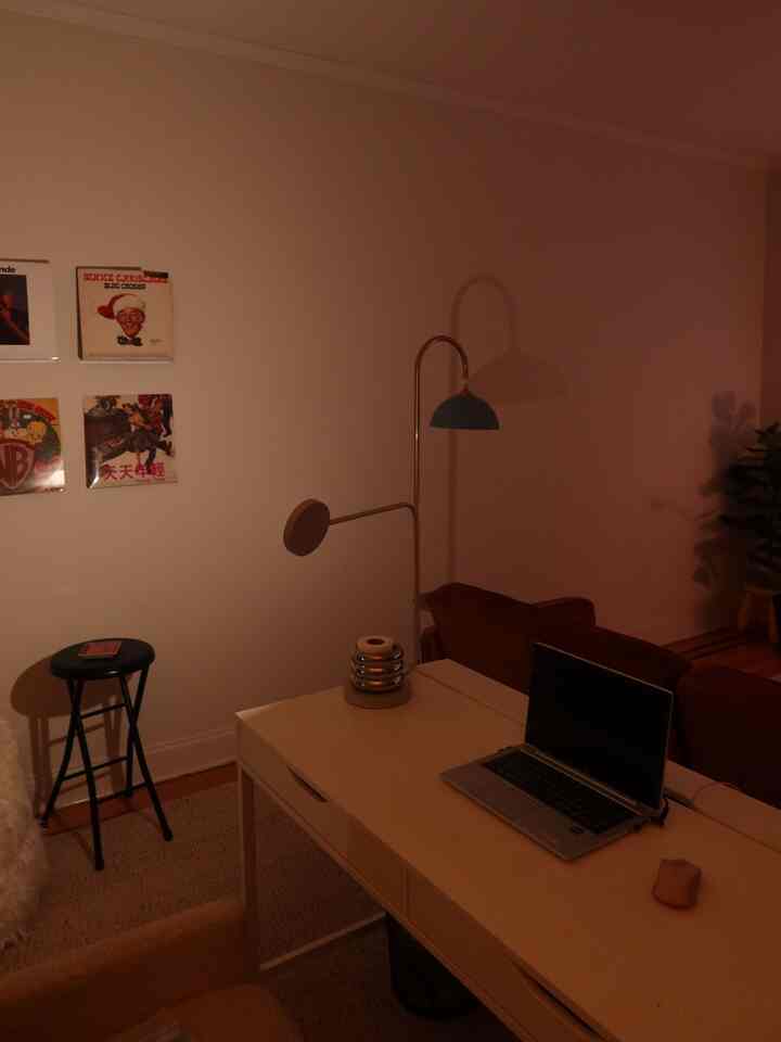 Warm brown and white toned home office study featuring a desk and standing lamp with cozy atmosphere