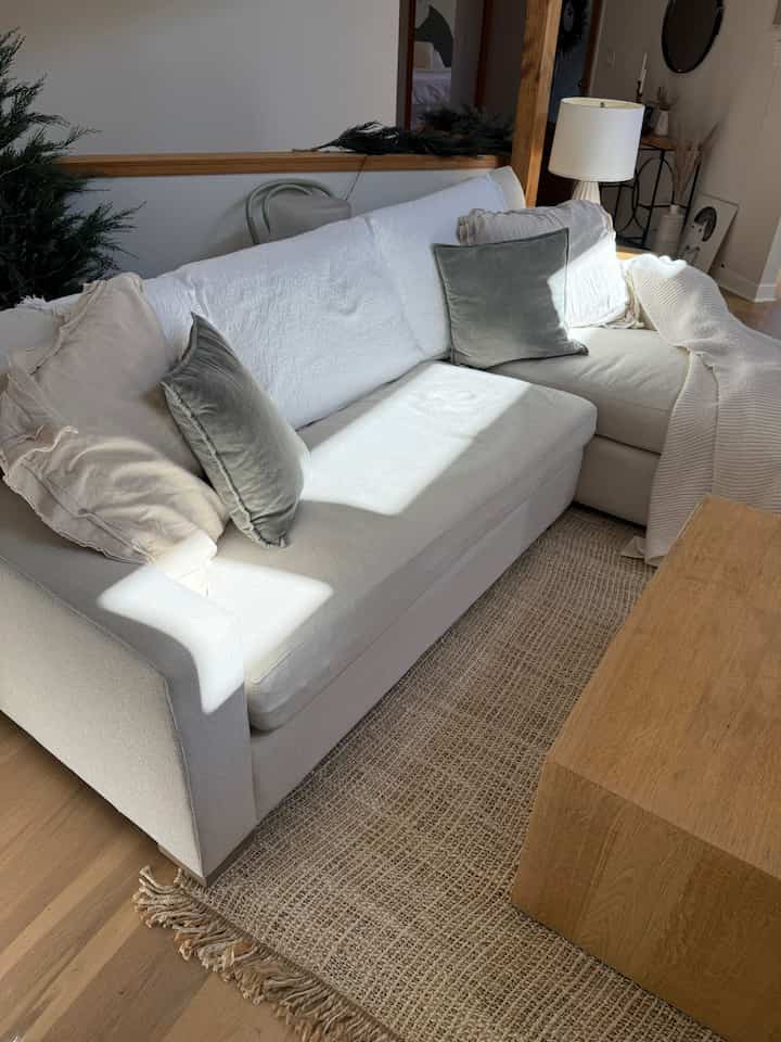 Warm natural tone living room featuring beige sectional sofa and wood-tone coffee table with a cozy atmosphere