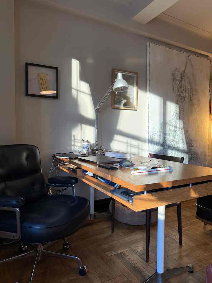 Warm wood tone and white mid-century modern home office with sunlight on desk and office chair