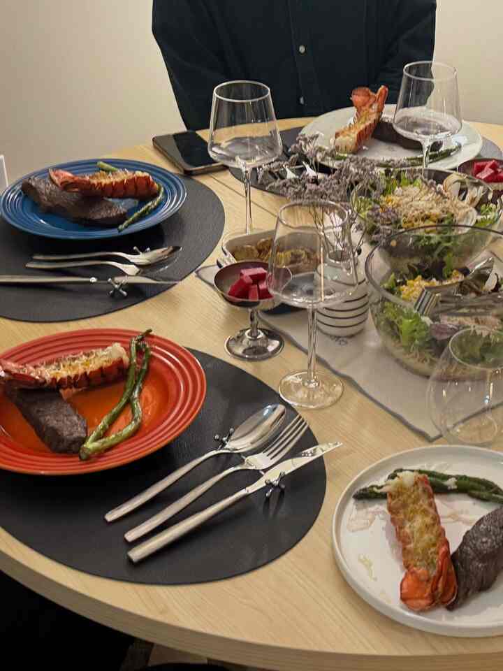 Bright wood-tone dining table with red and black accents featuring a two-person dining setup in a cozy dining space