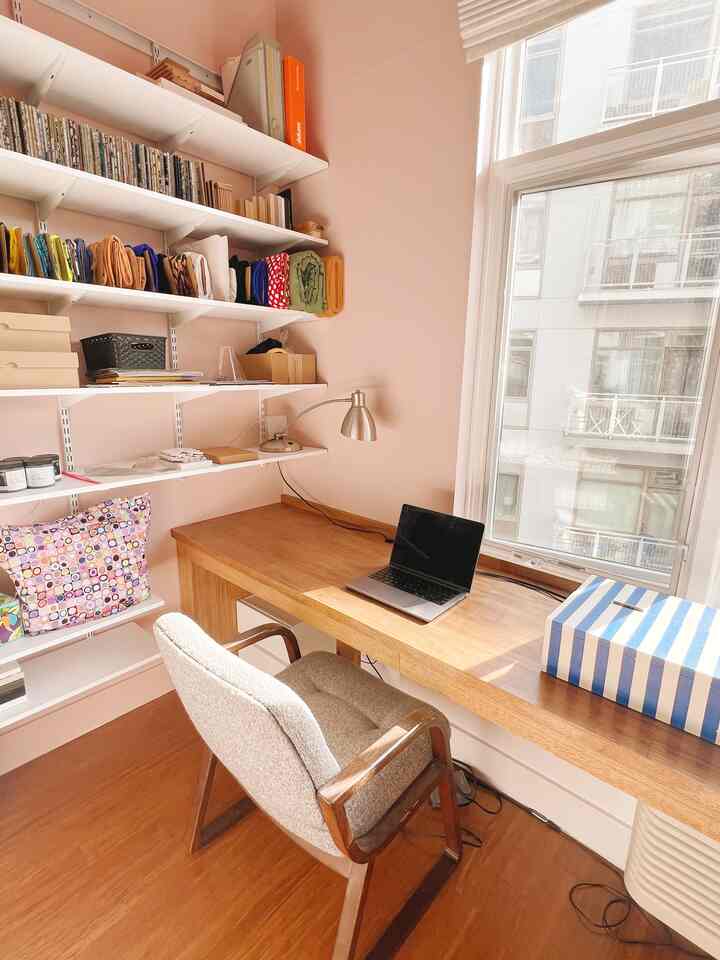 Beige walls and natural wood desk in a compact home office space