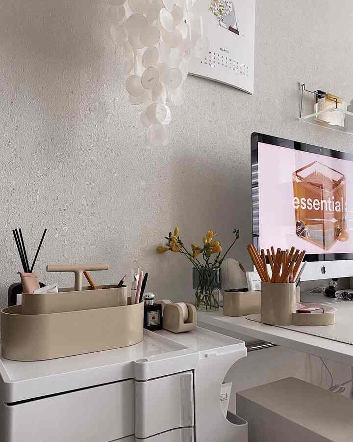 White and beige toned home office featuring a clean desk setup with yellow vase, creating a cozy atmosphere
