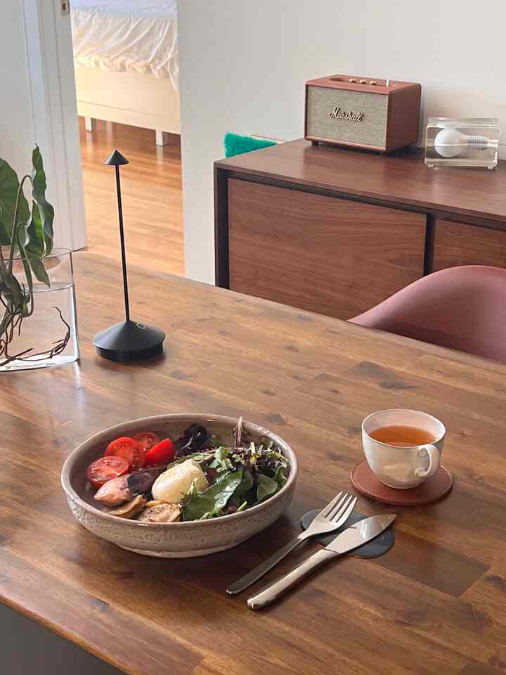 Brown wood tone dining room featuring a wooden table with a simple meal setting in a cozy space