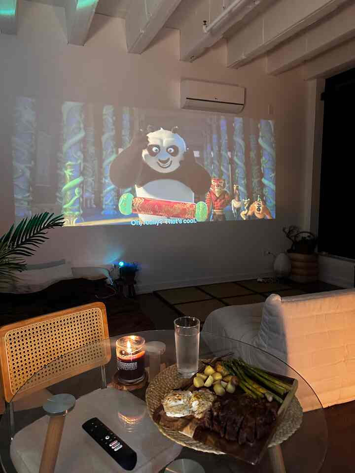 Natural wood-tone dining room featuring tatami mat, rattan chair, and home cinema creating a cozy atmosphere