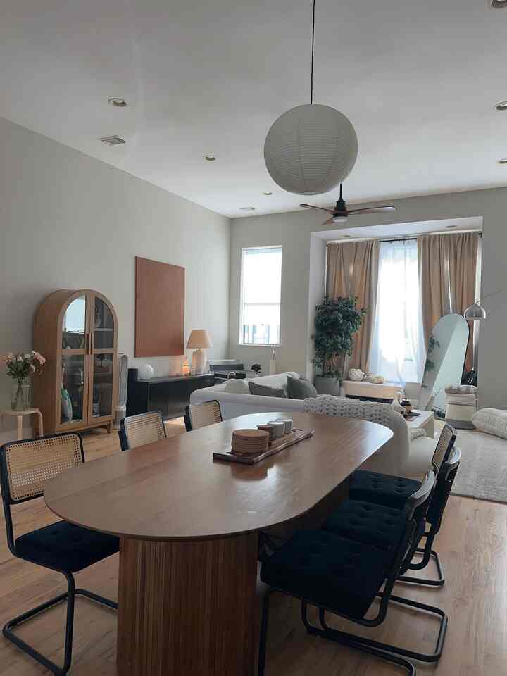 White and wood tone dining and living room featuring mid-century modern chairs with cozy interior atmosphere