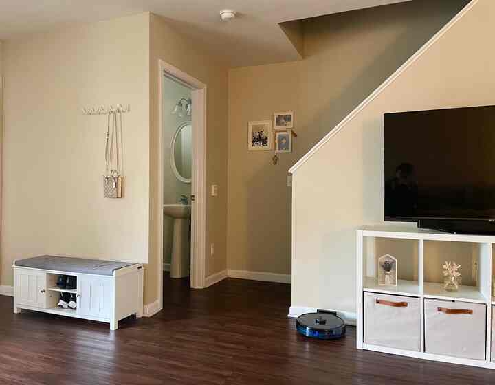 White and brown toned living room featuring TV stand and shoe storage bench with a clean, cozy atmosphere
