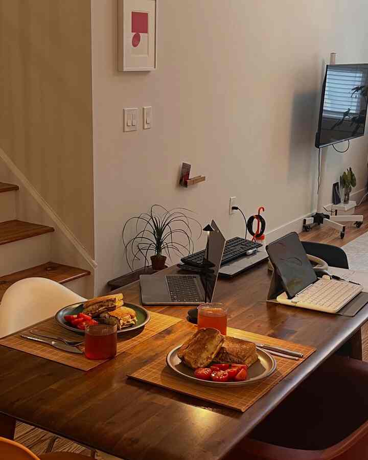Natural wood tone and white walled two-person dining and remote work space