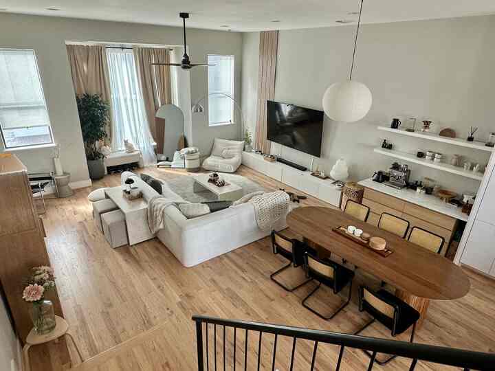 Ivory and wood-tone living and dining room featuring white sofa and wooden dining table in a cozy, minimalistic space