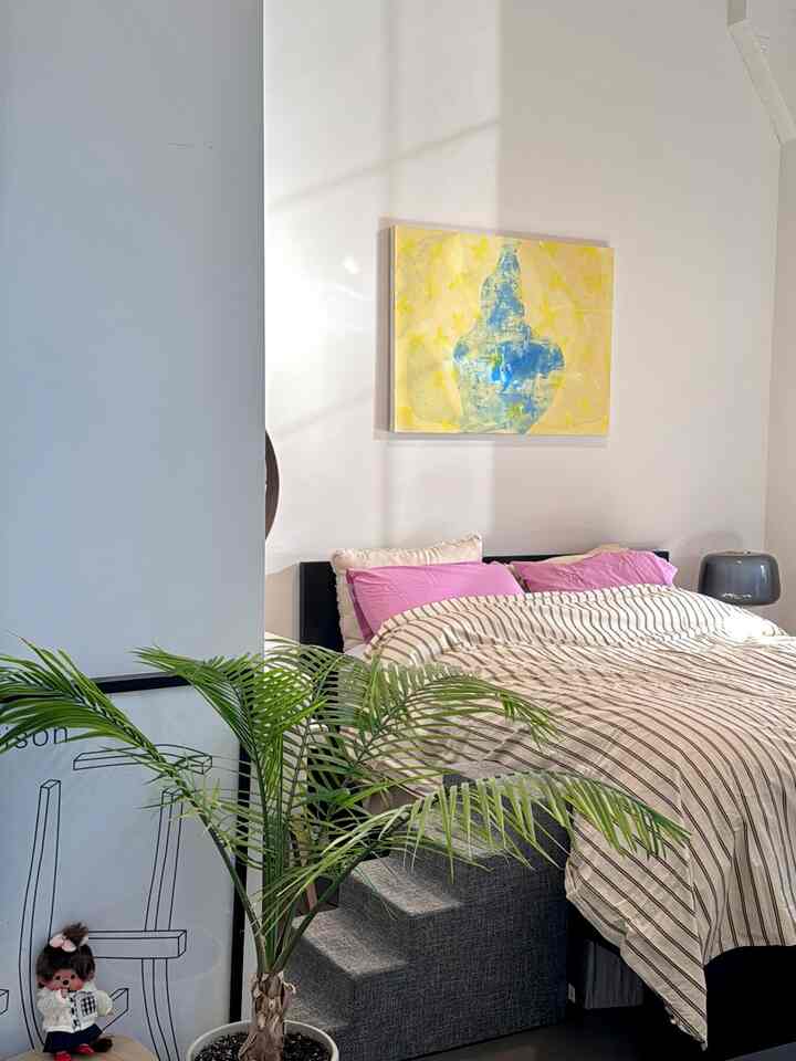 Modern white bedroom featuring dog stairs, bedding, and a table lamp with a cozy atmosphere