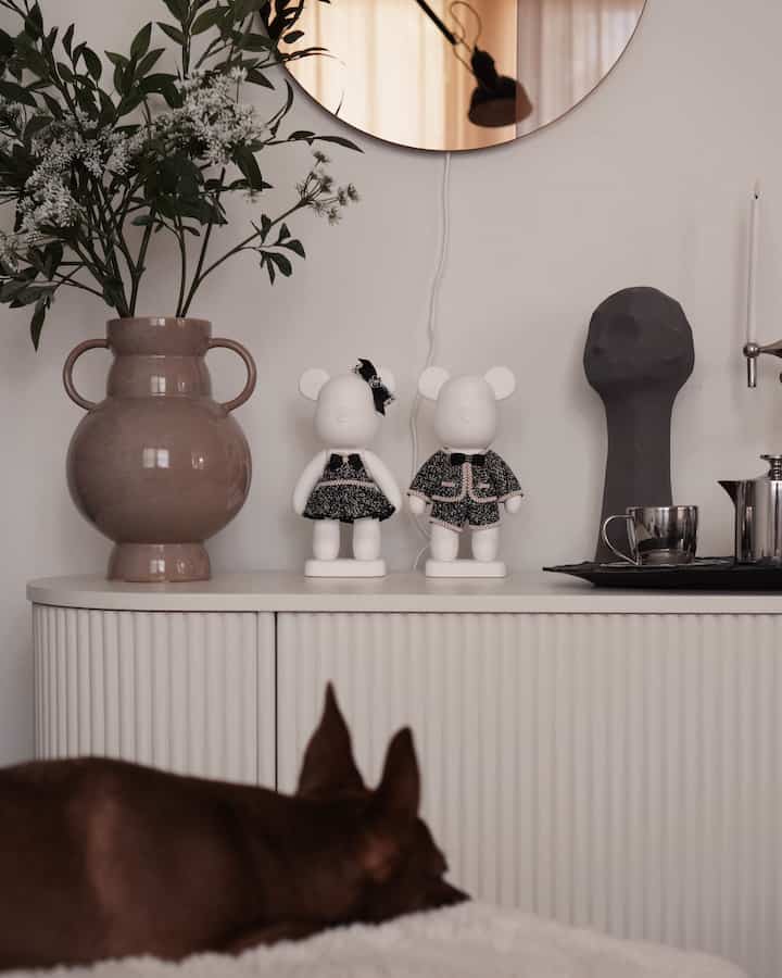 White-toned living room featuring a sideboard with figurines and sculptures creating a cozy atmosphere