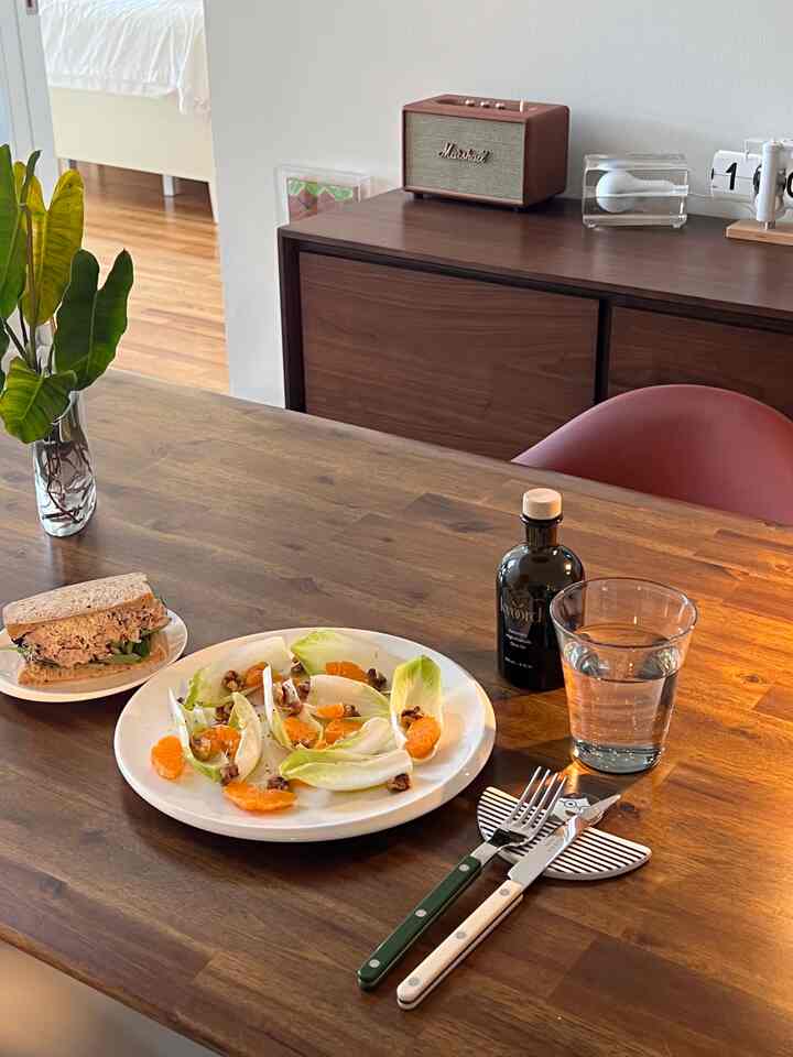 Wood tone dining room featuring a simple lunch on the table with stylish cutlery set, creating a cozy atmosphere