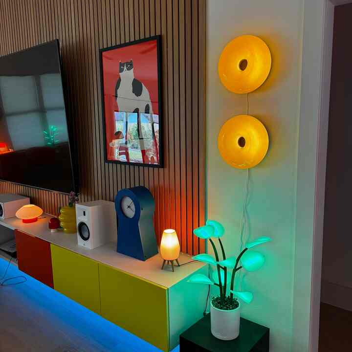 Colorful living room with vibrant storage cabinets, decorative lighting, and cat wall art creating a cozy atmosphere