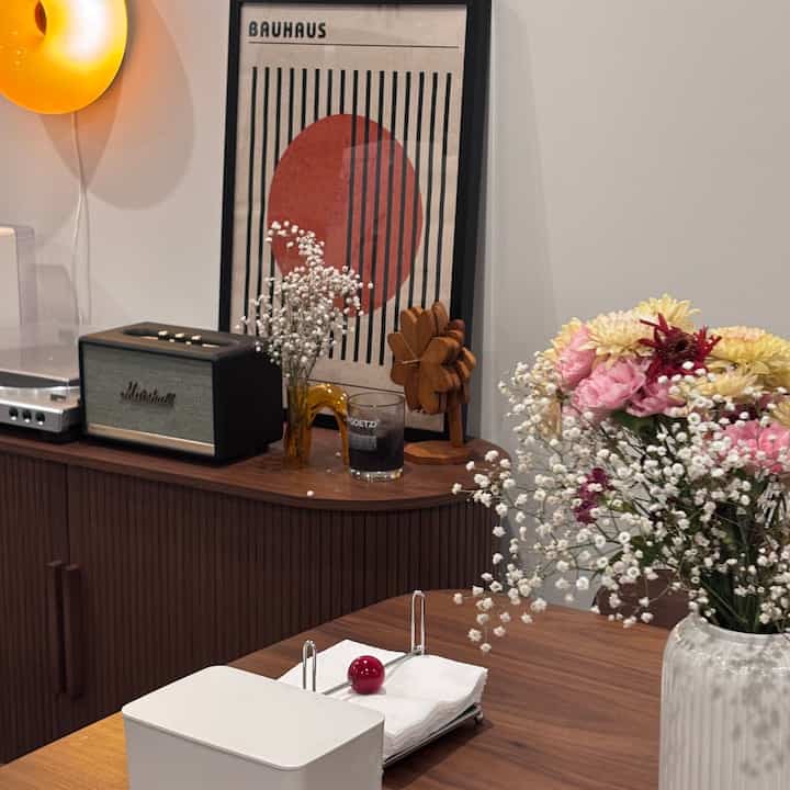 Warm brown wood tone mid-century modern dining room featuring floral vases and decorative items, creating a cozy space