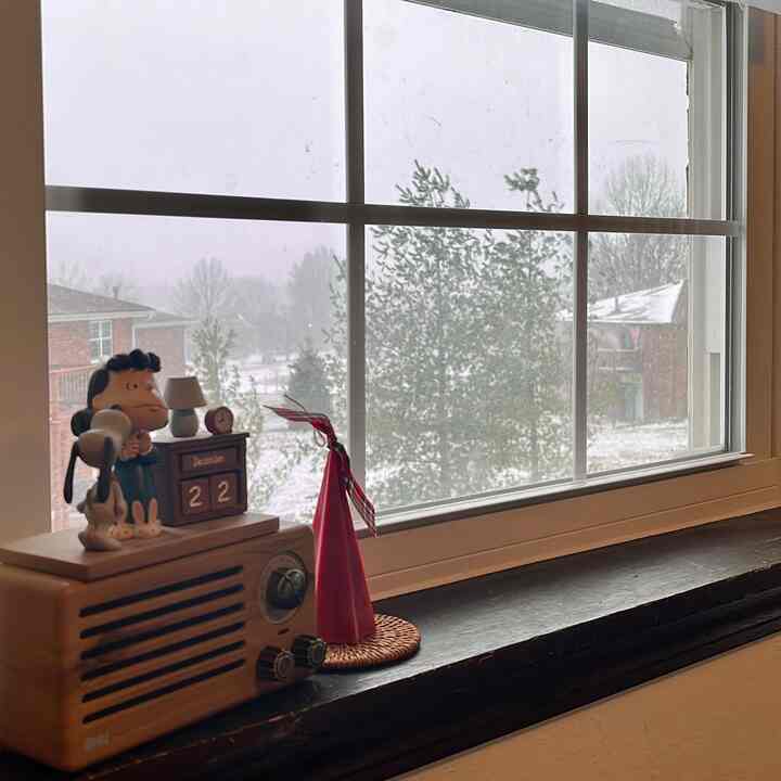 White and brown-toned window ledge with vintage radio and decorations in a wintery atmosphere