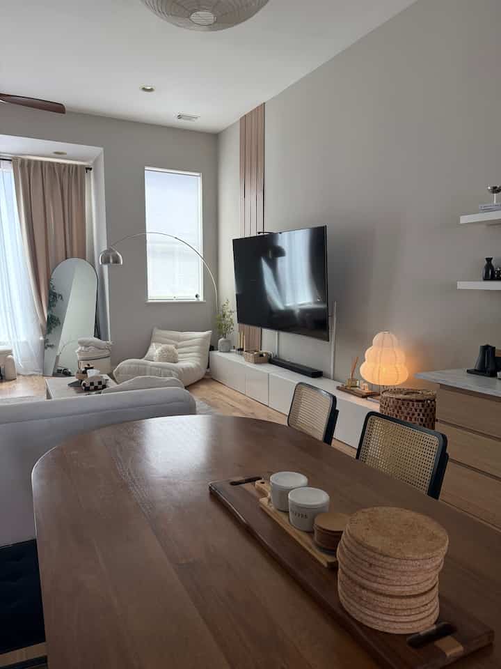 White and wood tone living and dining room featuring sofa and floor lamp in a Mid-Century Modern style space