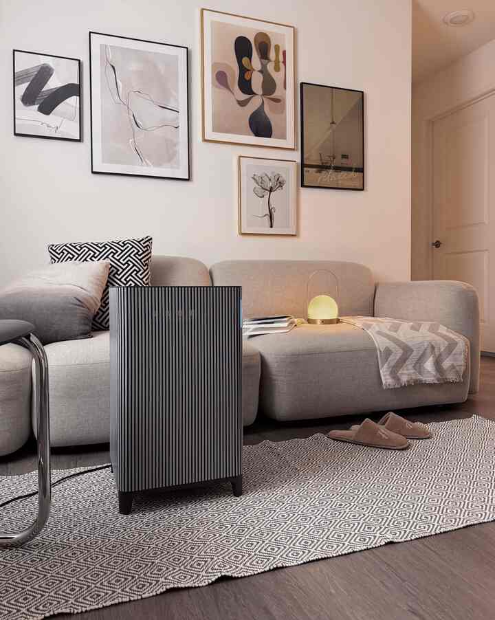 Light beige toned living room featuring a beige sofa, diamond-patterned carpet, and minimalist wall art, creating a simple atmosphere