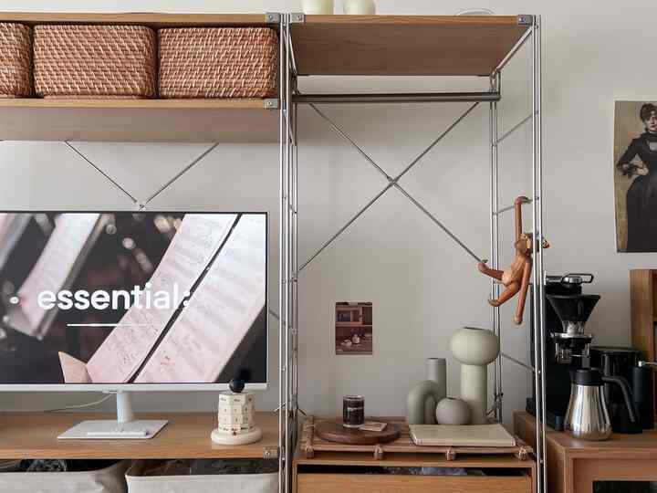 Wood tone and black accented studio apartment featuring a desk, coffee machine, and decorative objets creating a warm, stylish interior