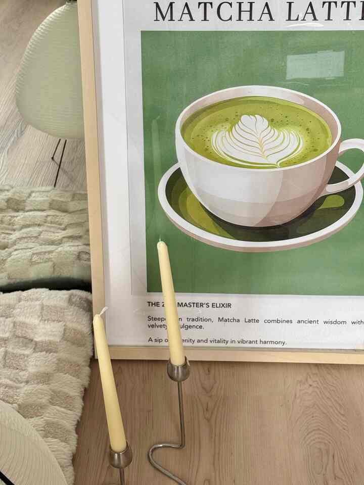 Natural style interior featuring wood tone floor, silver candlesticks, and green matcha latte poster