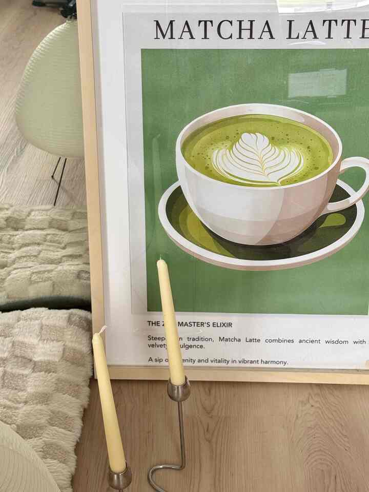 Natural tone living space featuring large green matcha latte poster and silver candlesticks with cozy atmosphere