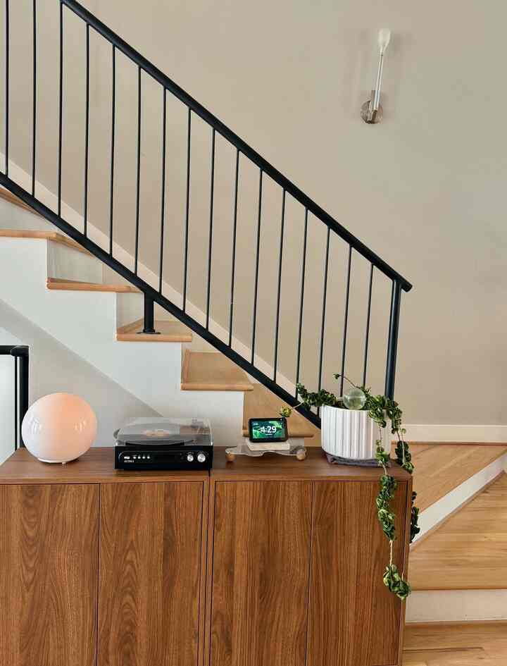 Wood tone and beige space featuring wooden stairs and storage cabinet with harmonious interior design