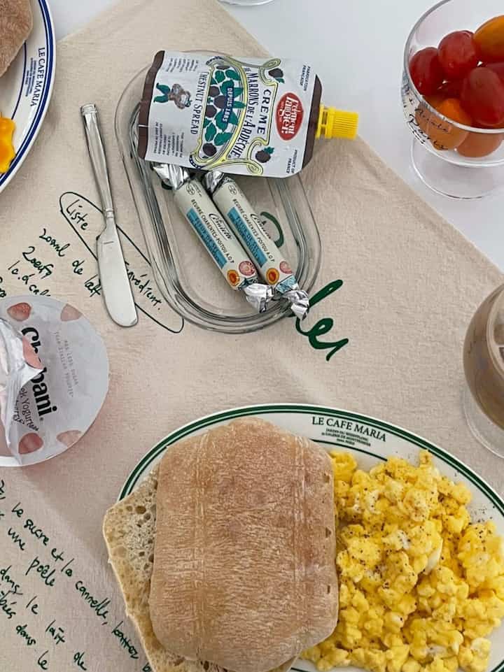 Natural and yellow tones kitchen dining table featuring bread, scrambled eggs, coffee creating a cozy home cafe atmosphere