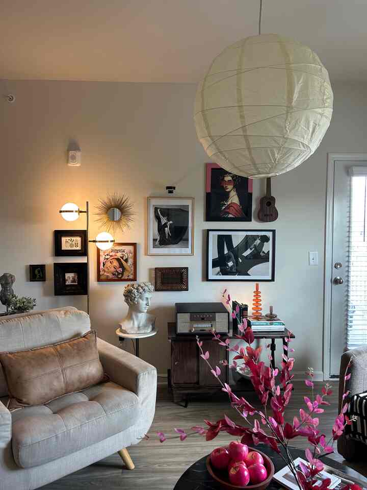 Ivory walls and natural brown furniture in a modern Mid-Century style living room featuring a gallery wall and floor lamp, creating a cozy atmosphere