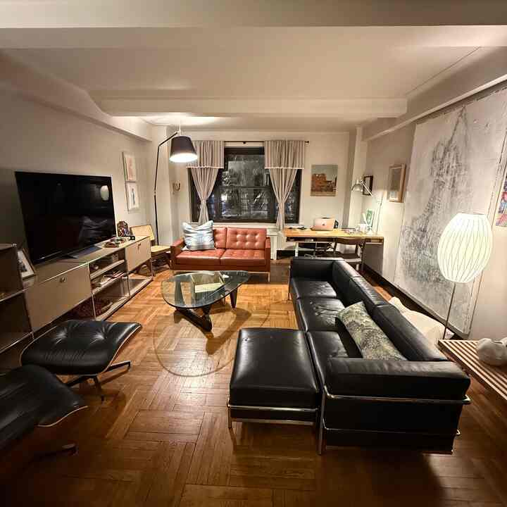 Wood tone and black dominant living room featuring two sofas, a desk, and various lighting creating a modern atmosphere