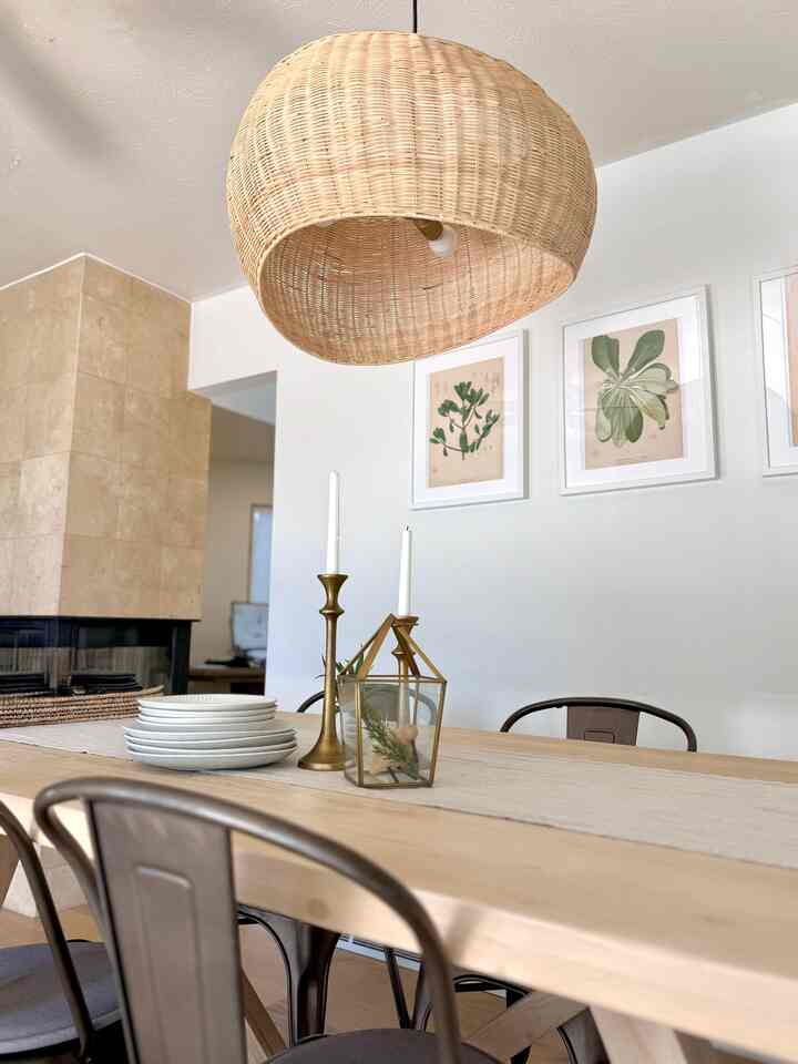 Beige and natural tone dining room featuring a natural wood dining table and wicker pendant light with a warm and cozy atmosphere