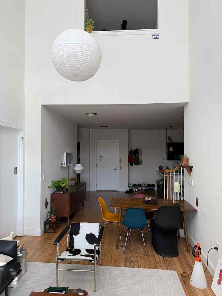 White and wood tone dining room featuring colorful dining chairs, clean and modern atmosphere