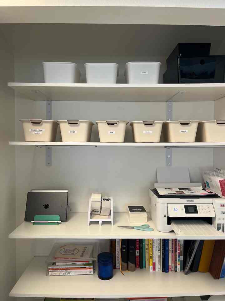 White-toned storage space featuring matching organized boxes and office items with a modern clean atmosphere