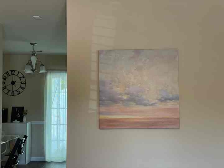 Beige wall living room featuring large wall art and soft, quiet natural light