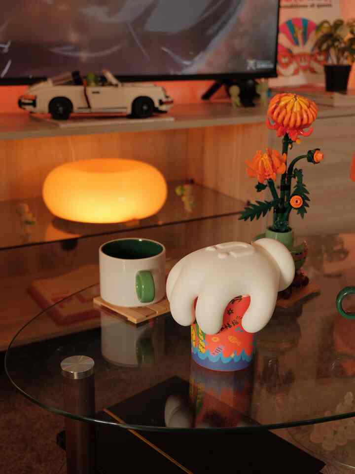 Warm orange and white toned living room featuring a glass coffee table with decorative candle creating a cozy atmosphere