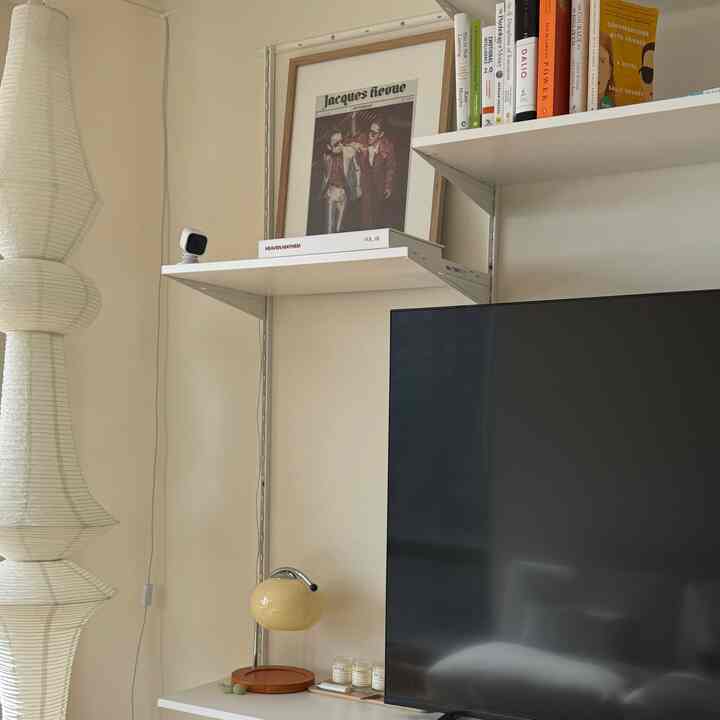 Cozy living room with ivory and beige toned wall shelves and a 55-inch TV