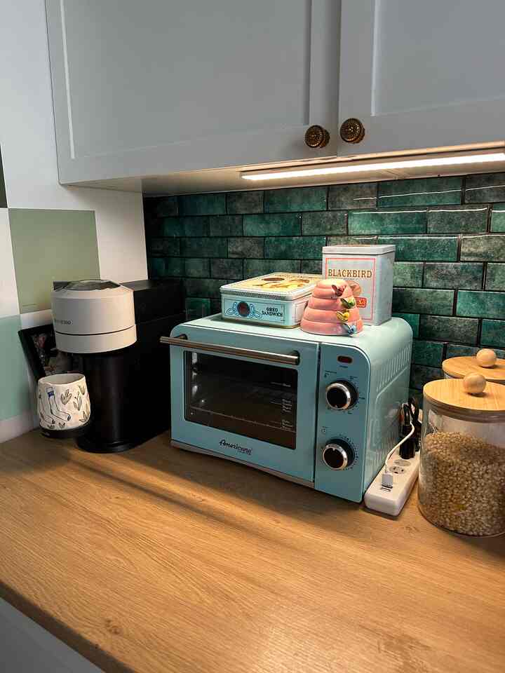 Blue and wood-toned kitchen space featuring a retro toaster oven and various kitchen accessories with a cozy atmosphere