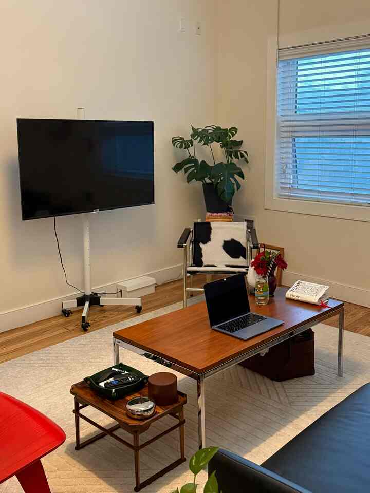Natural color living room featuring wood-tone coffee table and black sofa with modern atmosphere